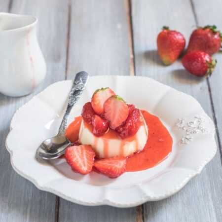 Panna cotta con sciroppo di fragole e fragole a pezzi